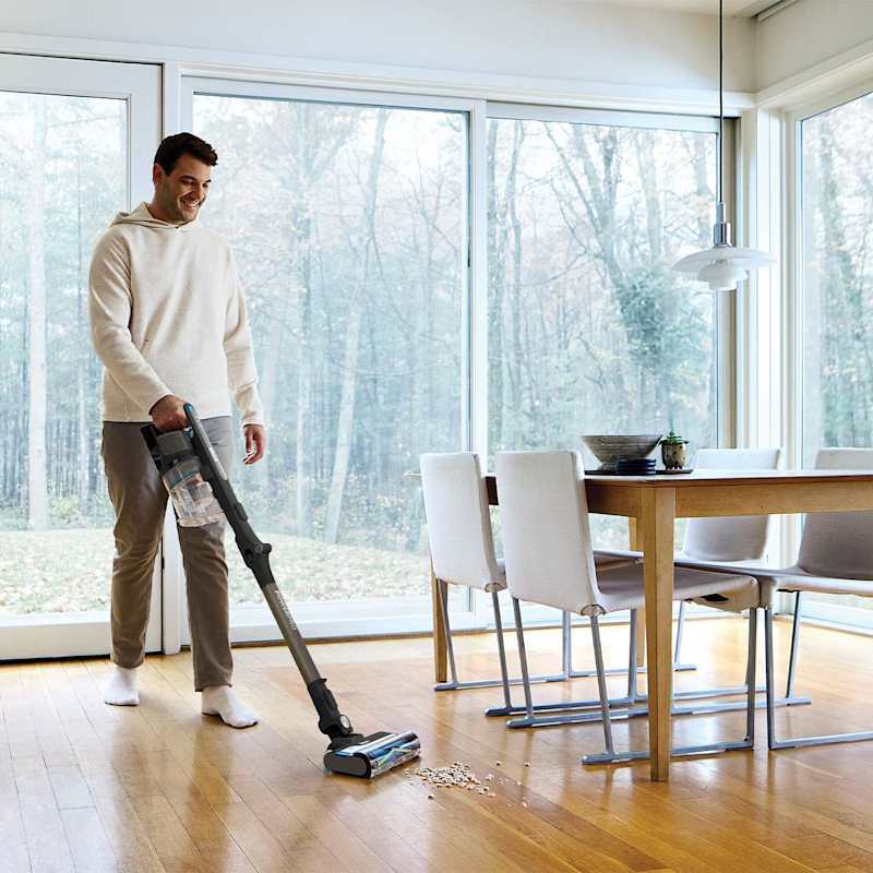 Vacuuming a hardwood dining room floor